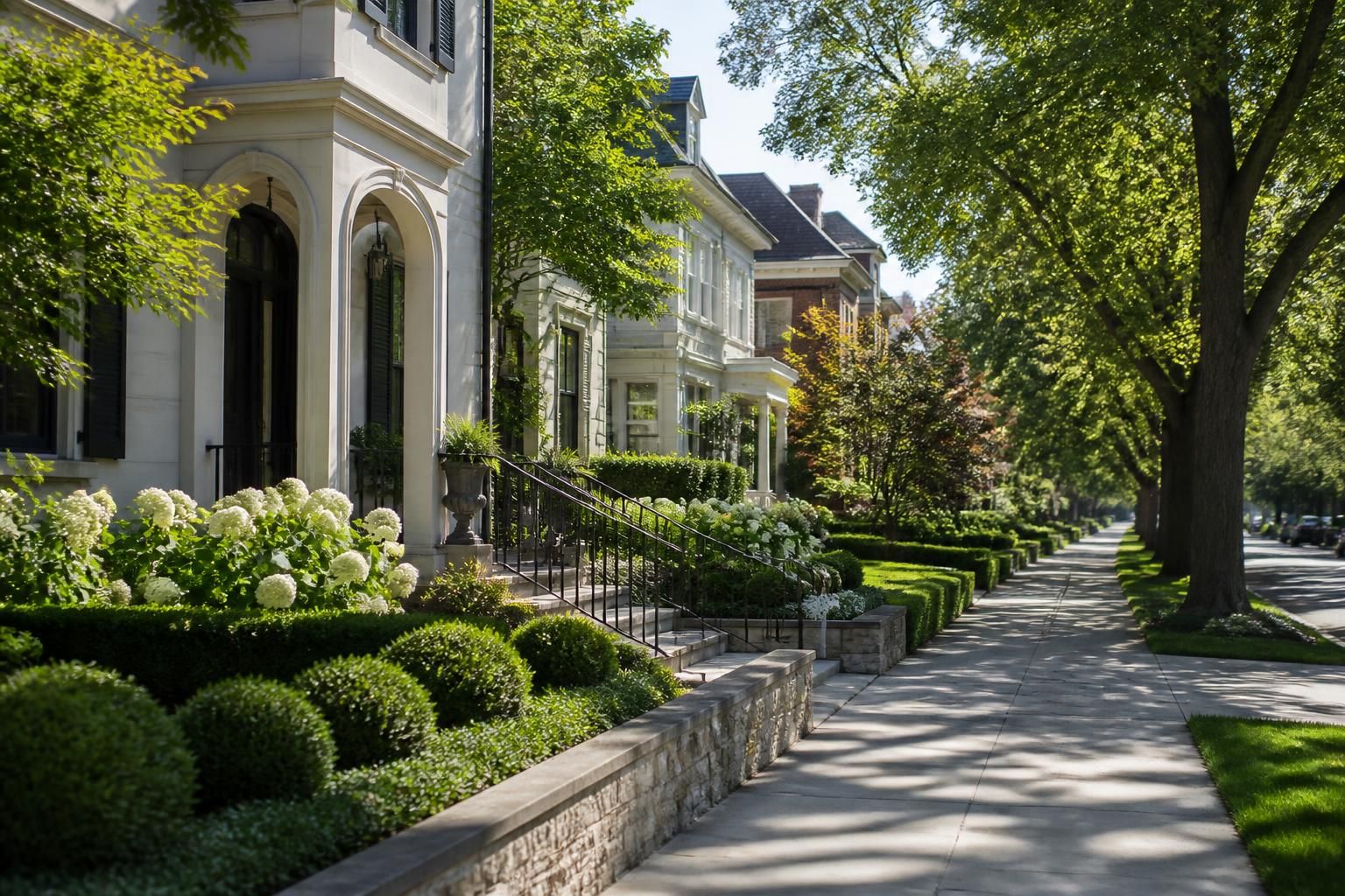 Upscale residential street with elegant homes and landscaping.